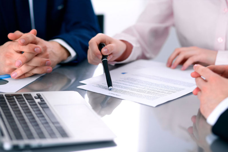 Image of business people reviewing  documents at a meeting.