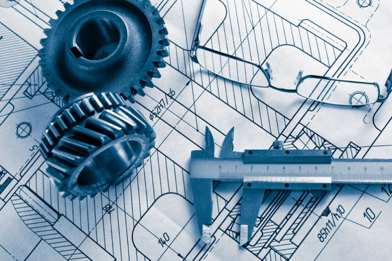 Image of Engineering blueprints with gears, calipers, and eyeglasses; technical drawings.